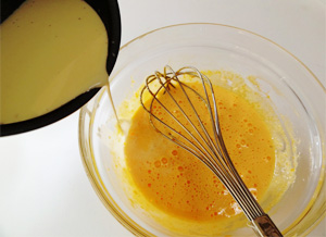 2.牛乳、生クリーム、しごいたバニラビーンズの中身を小鍋に入れ、50℃くらいに温め、①のボウルに少しずつ加え混ぜる。
